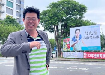 民進黨高雄市左楠區市議員擬參選人薛兆基與路口帆布廣告合影。（圖/薛兆基辦公室提供）
