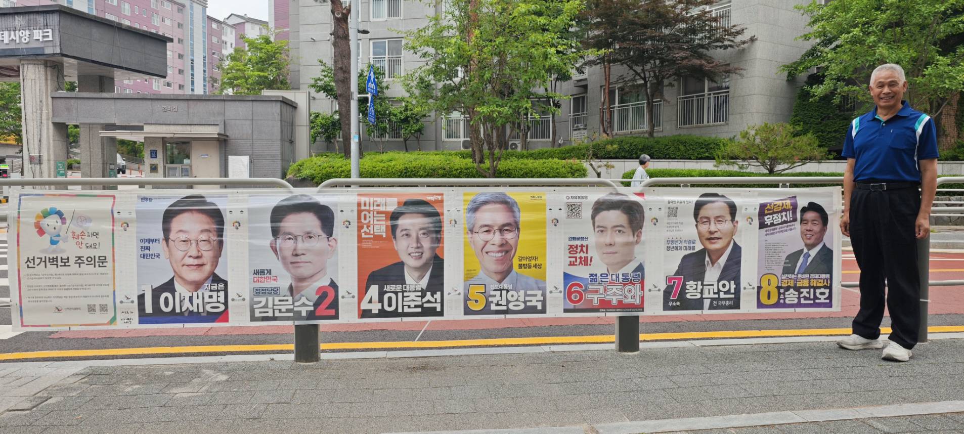 葉竹林於李在明擔任市長的城南市其中一個投票所前與總統選舉廣告合影。(圖/翻攝自葉竹林臉書)