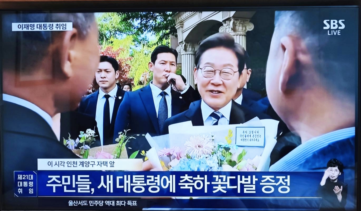 韓國新任總統李在明在4日離開住所前接受民眾祝賀。(圖/翻攝自韓國新聞台SBS現場畫面)