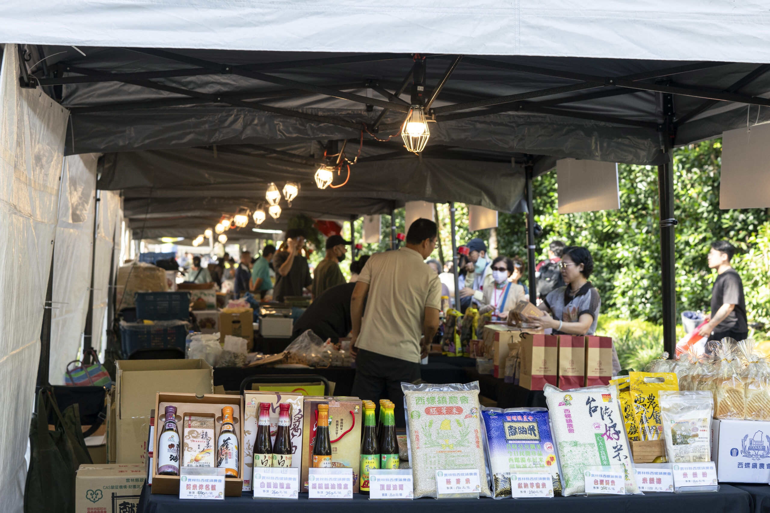 ▲超過35家攤商進駐臺大舟山路,展售具有雲林地方特色的蒜頭、花生、玉米、豆包、角螺、虱目魚、文蛤、有機竹筍、黑蒜土雞腿湯、紅殼雞蛋、醬油、蜂蜜等等,琳瑯滿目的優質農產品與創新加工品。(圖/國立臺灣大學提供。)